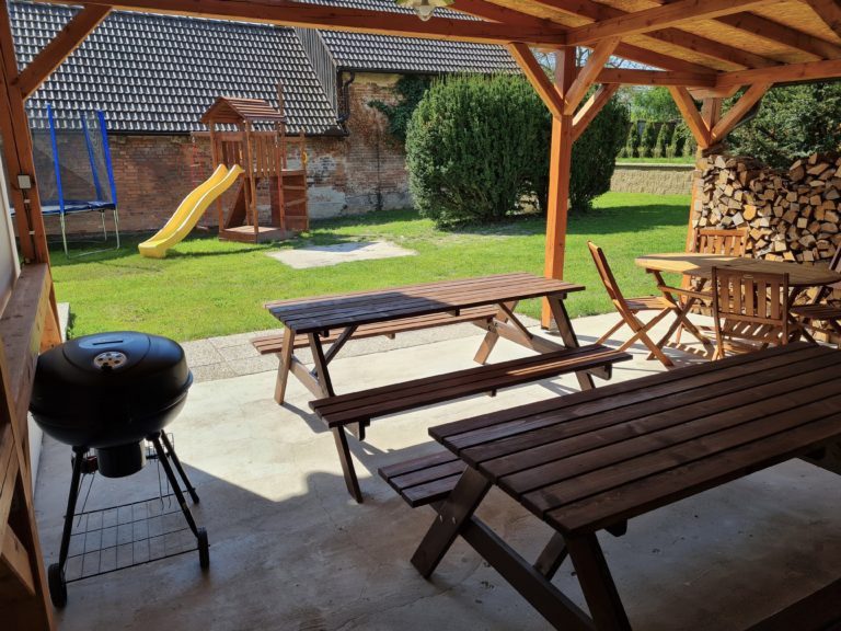 Kotlový gril a posezení na zahradě, v pozadí skluzavka
